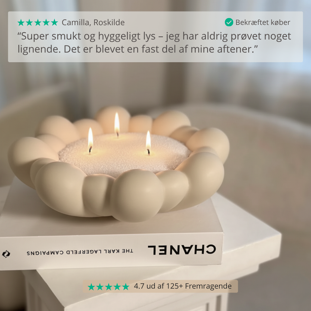 Lysestage med tre lys på en overflade, med en kundeanmeldelse